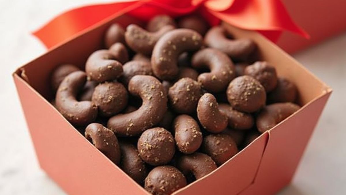 Cadeaubox met chocoladebedekte cashewnoten, mooi verpakt met een strik.