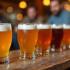 Diverse Belgische tripel bieren op een houten tafel.