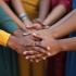 Diverse groep vluchtelingen die elkaar de handen vasthouden.