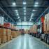 Een druk logistiek centrum met vrachtwagens en medewerkers die pakketten organiseren
