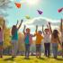 Een groep kinderen die kleurrijke papieren vliegtuigjes vliegt in een park
