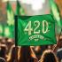 Een groep mensen met groene spandoeken en cannabisversiering die 420 Dag vieren.