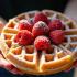 Een heerlijke wafel met poedersuiker en aardbeien in iemands handen.