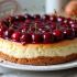 Een klassieke kersen cheesecake met felrode kersen en een boterige koekjesbodem.