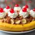 Een kleurrijke bananensplit dessert met slagroom en kersen