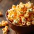 Een kleurrijke kom met caramel popcorn op een houten tafel