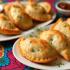 Een kleurrijke tafel met een assortiment empanadas.