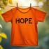Een levendig oranje shirt dat in de natuur hangt