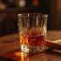 Een luxe glas cognac met een sigaar op een houten tafel.