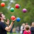 Jongleurs Dag gevierd met kleurrijke jongleerballen in de lucht in een park.