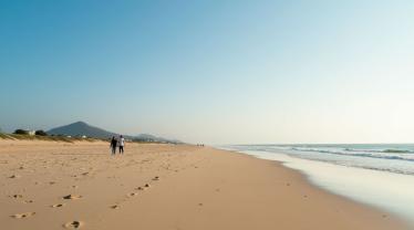 Mensen die blootsvoets op het strand wandelen