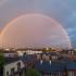 Regenboog over een regenachtig Belgisch stadsgezicht