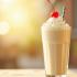 Romige vanille milkshake met slagroom en een kers bovenop