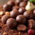 Truffels uitgestald op een houten tafel met cacao, noten en vruchten.
